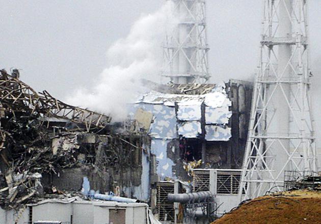 图片拍摄于2011年3月15日。东京电力公司通过共同社提供的这张图片显示了受损的福岛第一核电站4号反应堆，图中的滚滚白烟来自3号反应堆