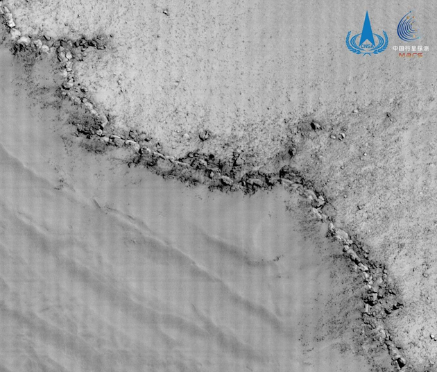 环绕器高分相机拍摄蒙德环形坑边缘影像，空间分辨率约0.5m，该环形坑直径约91km，图像展示了蒙德环形坑坑缘的地貌特征，图左下部为环形坑内部，坑缘可见明显向坑内坍塌的现象。