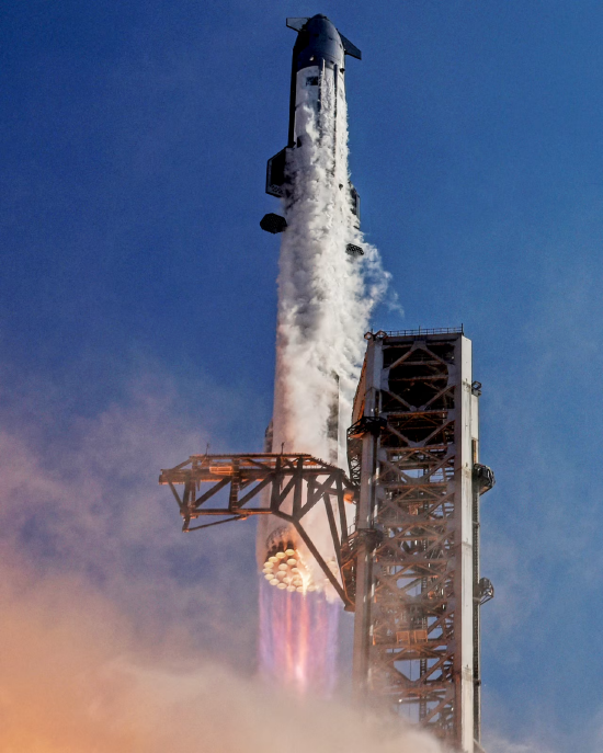 今年美国得克萨斯州，SpaceX 星舰搭配超重型助推器点火升空，发射台底部火光浓烟喷涌，一旁矗立巨型发射塔