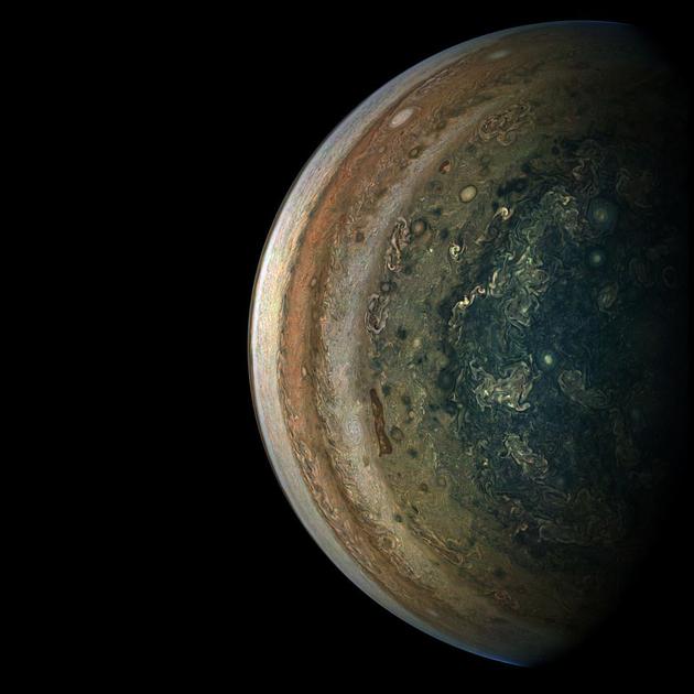 这是从一个新的视角展示吞噬木星的巨大风暴和漩涡。美国宇航局表示，木星“后视镜”图像拍摄于2018年9月6日，当时朱诺号正值第15次近距离飞越木星。此时，该探测器距离木星顶部云层大约89500公里，位于南纬75度。