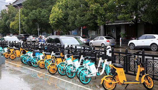 停放在路边的共享电单车。图片来源：视觉中国
