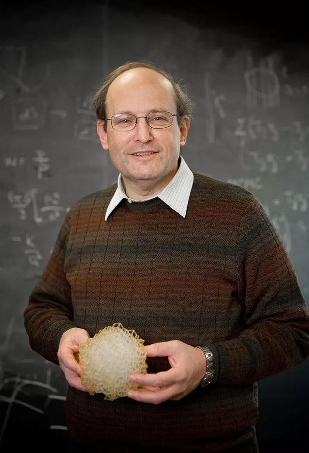 Paul Steinhardt手持一个准晶体模型。来源： 普林斯顿大学董事会