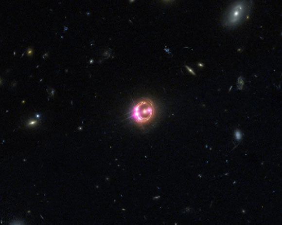 引力透镜系统RXJ1131-1231图像，中心可以看到前景星系，以及周围的四个背景类星体鬼影。估算认为这个透镜星系中存在数万亿颗行星