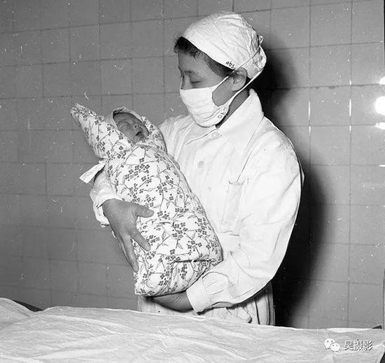 1957年元旦,助产士为这个刚出生的宝宝刘芪祝福.关平 摄