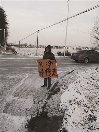 小伙寒潮中举牌两小时 提醒司机注意安全