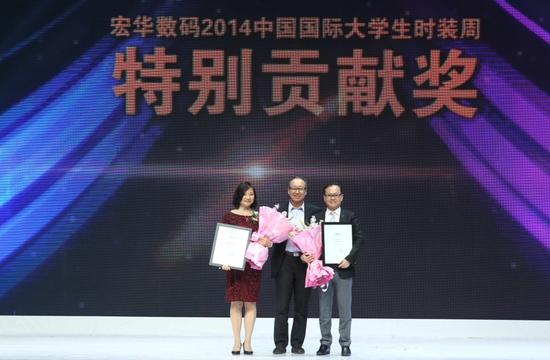 中国服装设计师协会主席李当岐为获得2014中国国际大学生时装周特别贡献奖的杭州宏华数码科技股份有限公司和九牧王股份有限公司颁奖。