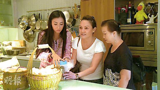 张柏芝妈妈（中）在厨房帮忙处理张柏芝“婆婆”从云南带到香港的鸡蛋，厨房墙上挂满大大小小的锅。