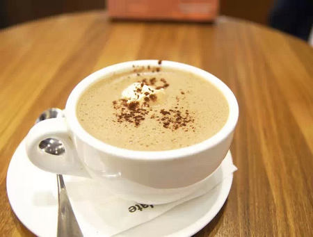 awfully chocolate 肉桂色的热巧克力,顶部有一勺淡黄色的鲜奶油,上面