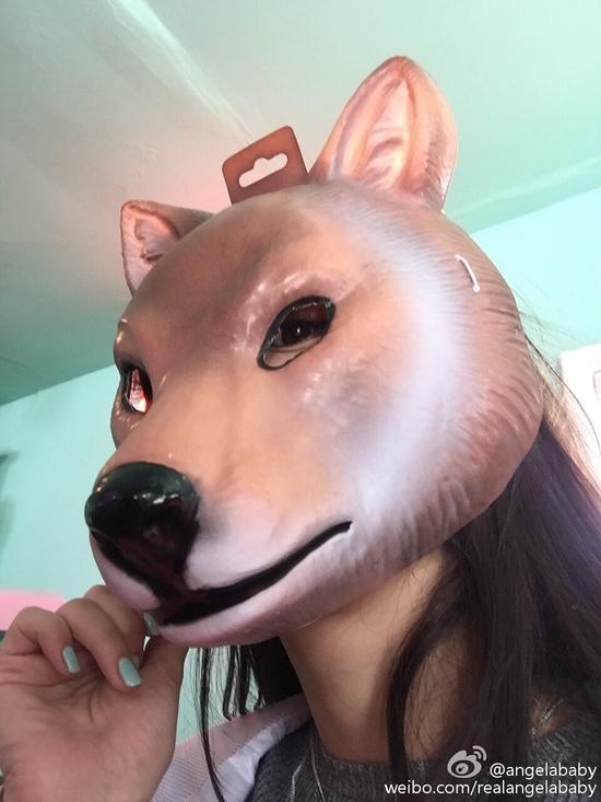 "照片中,baby披散着长发,戴着巨大的狗头面具,只露出了左边眼睛.