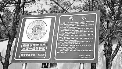立在水库边的饮用水水源一级保护区告示牌.