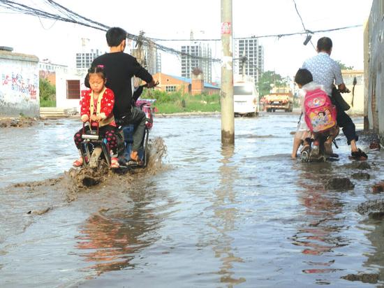 郑州街道污水井冒污水100多名小学生每天上学走水路