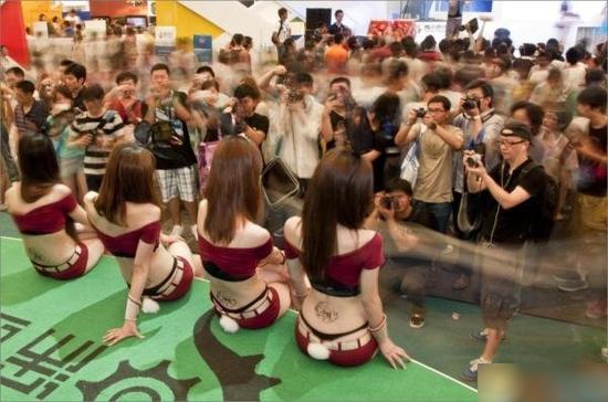 2011年7月28日，四位showgirl露出丁字裤，坐在展台上摆姿供参观者拍照。