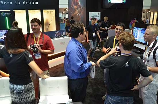 图8（海外玩家在展台前与工作人员讨论）