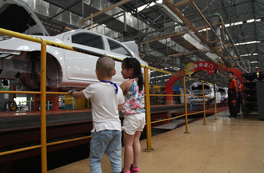 小朋友们观看汽车作业线