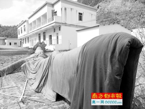 在惠城区公安分局保管的疑似乌木，出水半个多月，仍披着湿漉漉的棉被，堆放在露天的院子里。