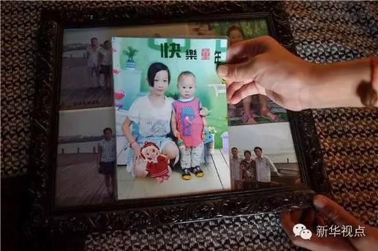 刘思圆在家中展示自己与弟弟的合影照片（7月27日摄）。目前，刘思圆的父母带着弟弟在浙江打工。新华社记者 张端 摄