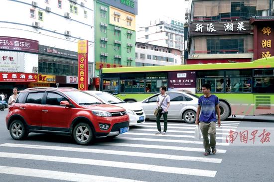 在南宁秀灵路秀隆商业街前，行人在斑马线上“险象环生”。
