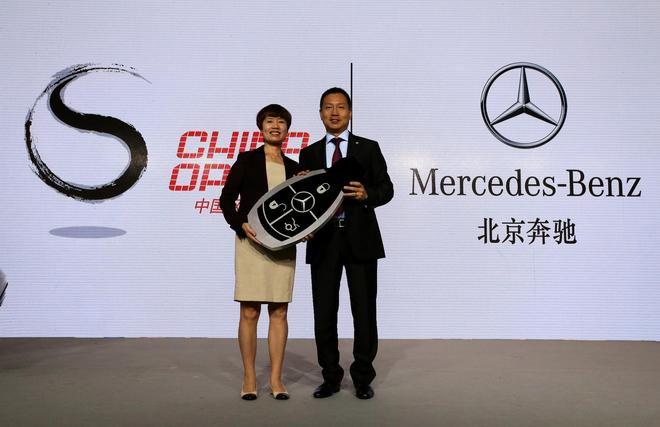 奔驰销售公司高级执行副总裁李宏鹏先生将象征合作启动的模型钥匙交到吴佩华女士手中