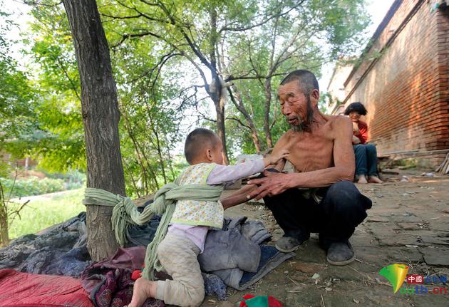 听到爸爸的声音，小庆太赶紧转身走向他的爸爸王孟义，希望爸爸能解开他身上的编织袋绳，能抱他一会儿。