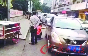 环卫工蹲着擦车上的刮痕。