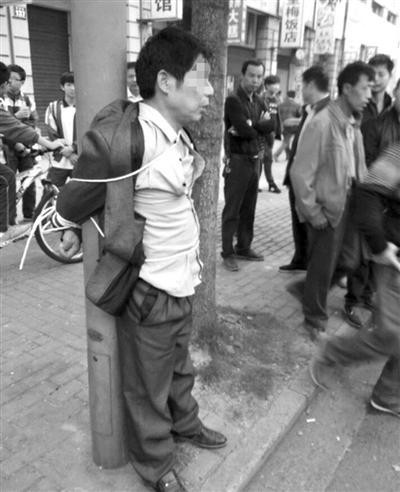 被绑在灯柱上的男子