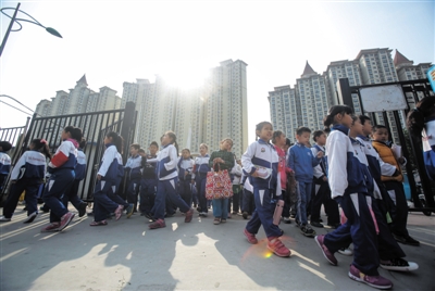 燕郊汇福实验学校周边高楼四起，附近社区多达14个。近几年学生暴增，目前有5300余学生，挤在这一所学校上课。摄影/新京报记者 彭子洋