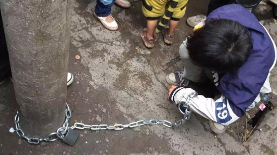 11月2日下午,昆明市西山区杨家路一男童被人用崭新铁链锁在路边的电线