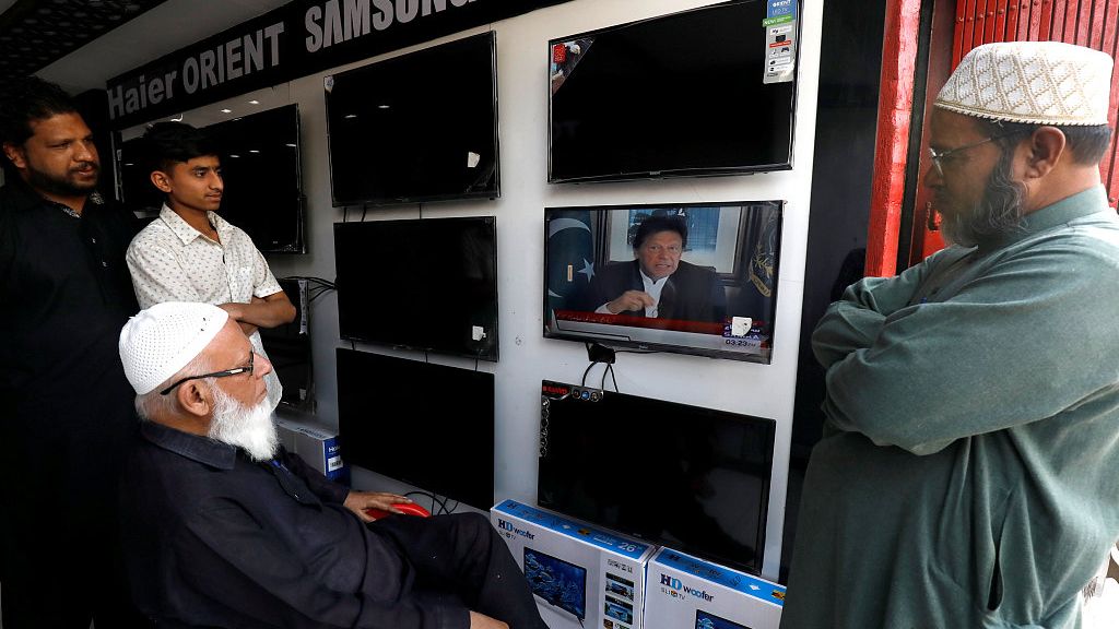▲2019年2月27日，巴基斯坦卡拉奇一家电器店，人们观看巴基斯坦总理伊姆兰·汗发表电视讲话。 图片来源：视觉中国