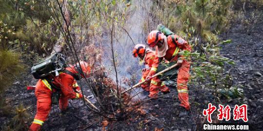 消防员正在清理火场。　王绍刚 摄