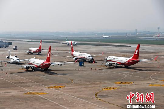 上海航空公司的9架波音737MAX机型飞机停在虹桥国际机场停机坪上，工作人员正在对飞机进行检查。　殷立勤 摄