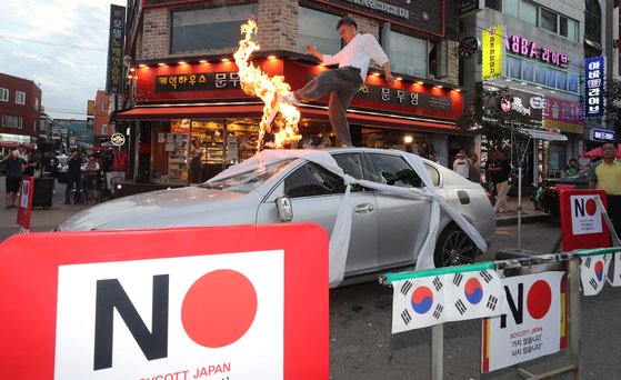 日系车被砸:日系车要哭 韩国市场销量遭腰斩民众当街砸车(图) 韩国民众在日系车上焚烧谴责日本限贸的声明(news 1)