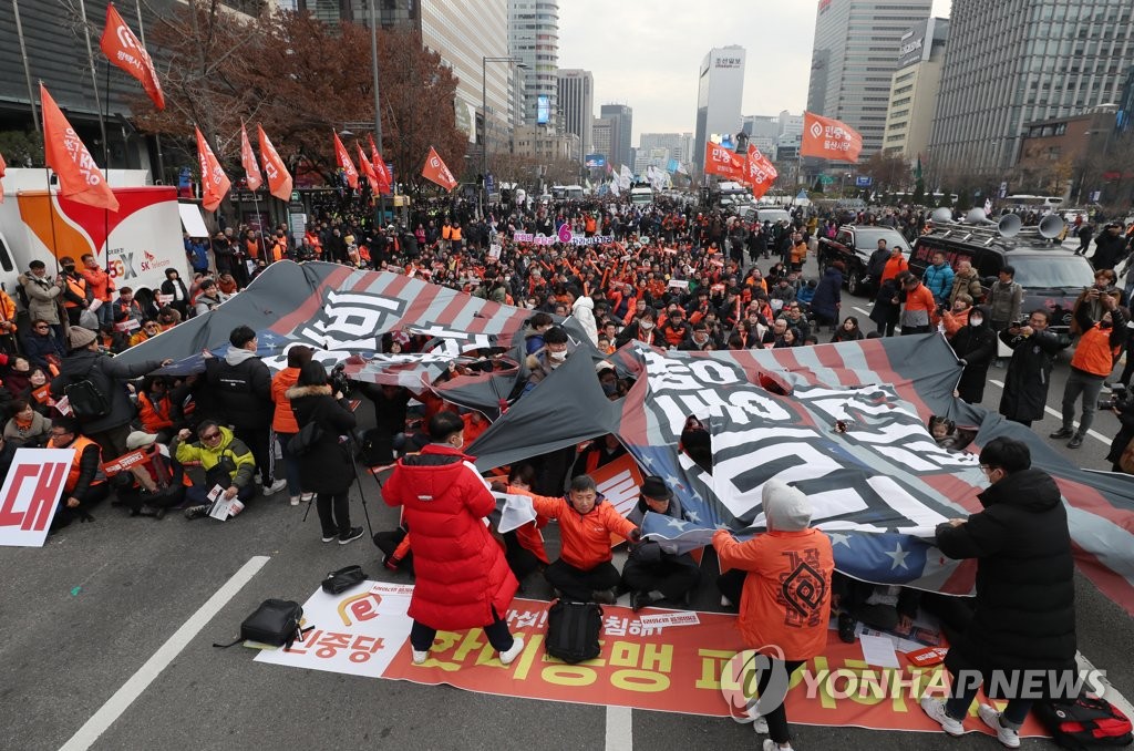  11月30日，韩国民众在美国大使馆前撕毁星条旗。（韩联社）