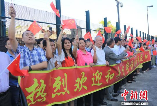 华人华侨挥舞五星红旗在码头迎接。江山 摄