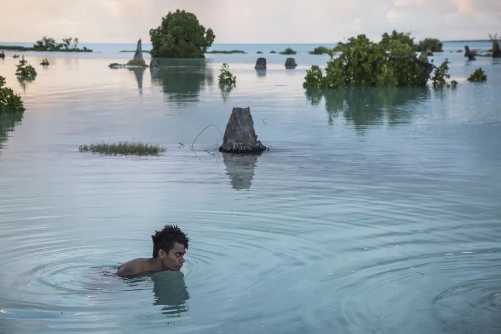▲太平洋岛屿国家基里巴斯被海水淹没的村庄，一名少年正在游泳。（联合国儿童基金会）