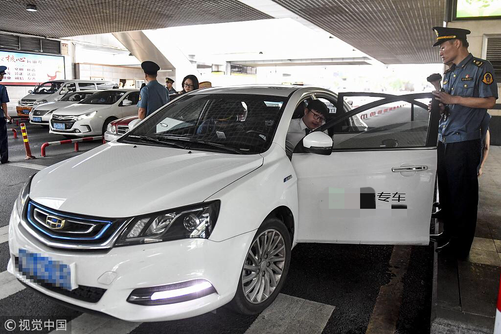 2018年5月,广州市的执法人员在广州东站对网约车资质进行核查。图/视觉中国