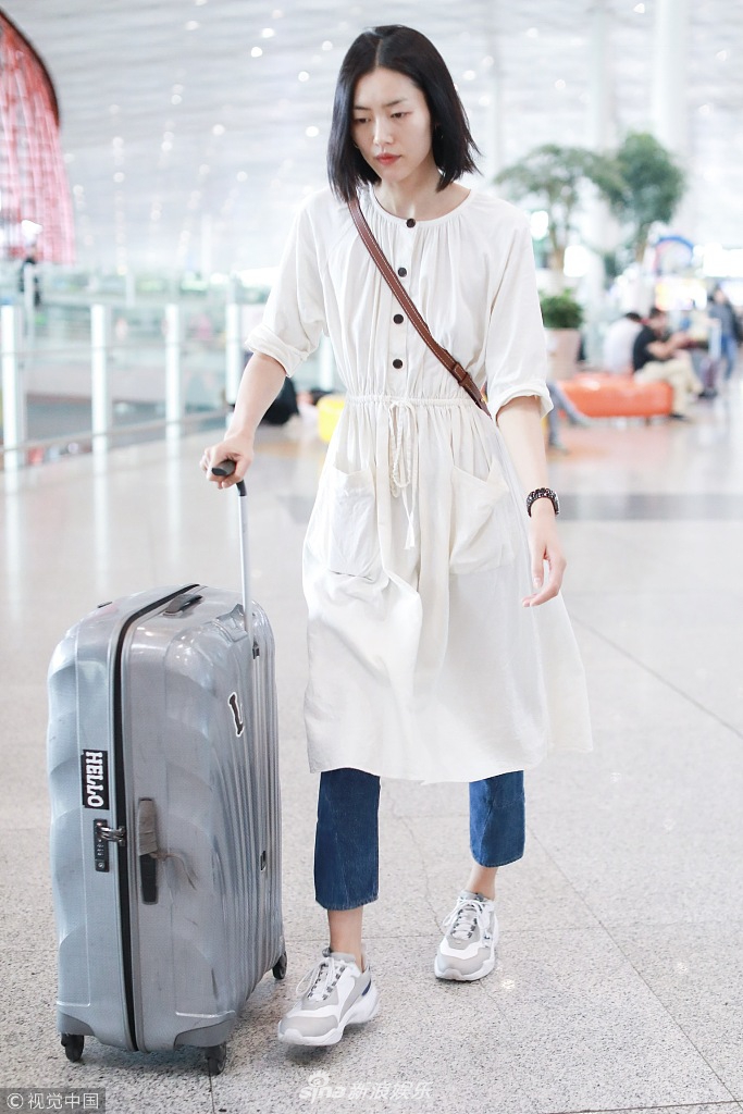 刘雯全程面无表情,一个人斜挎背包推着行李箱若有所思.