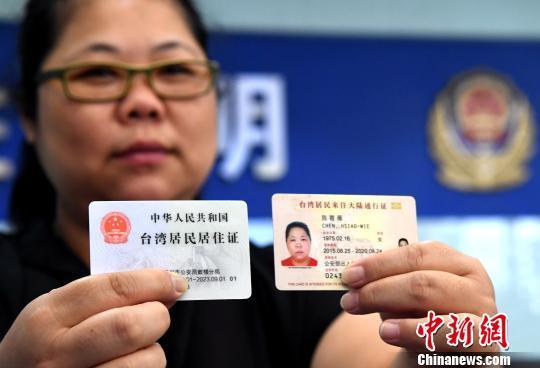 资料图：台胞陈筱薇展示自己领到的台湾居民居住证和其台湾居民来往大陆通行证。　张斌 摄