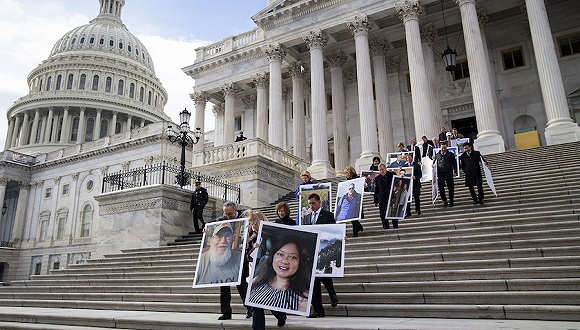  1月16日，美国华盛顿，议员手持受到政府停摆影响的联邦工作人员的巨幅照片，呼吁特朗普重启政府。图片来源：视觉中国