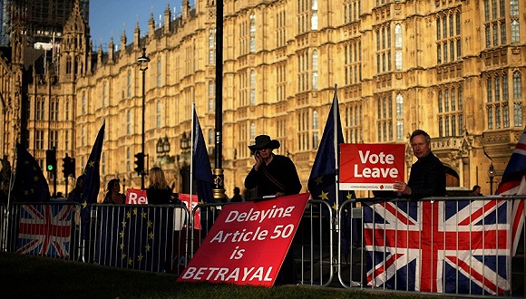  2月26日，伦敦，英国脱欧活动人士举着标语牌在下议院外示威。