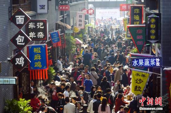  资料图：10月7日，国庆假期的最后一天，位于新疆乌鲁木齐市南郊闲来小镇的“宽窄巷子”美食街依然人头攒动，游客络绎不绝。据介绍，开业不久的“宽窄巷子”美食街，在国庆长假期间成为当地民众必到的休闲娱乐场所之一。 中新社记者 刘新 摄