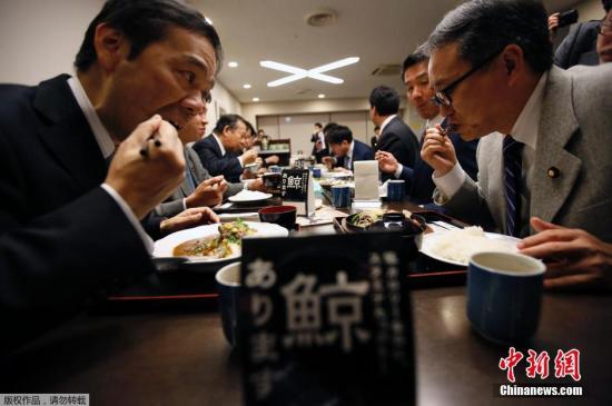 资料图：当地时间2014年11月19日，日本东京，日本议员二阶俊博等人在餐厅的鲸肉促销活动上吃鲸肉餐，试图通过该活动推动恢复捕鲸业。