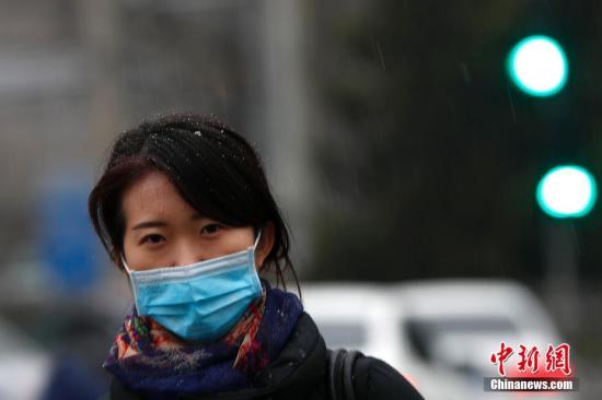 雨雪中出行的行人。 中新社记者 富田 摄