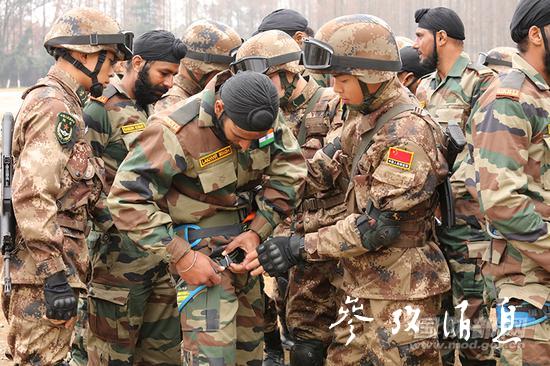  中国军人正在帮助印度军人检查锁扣，图片来源：国防部网