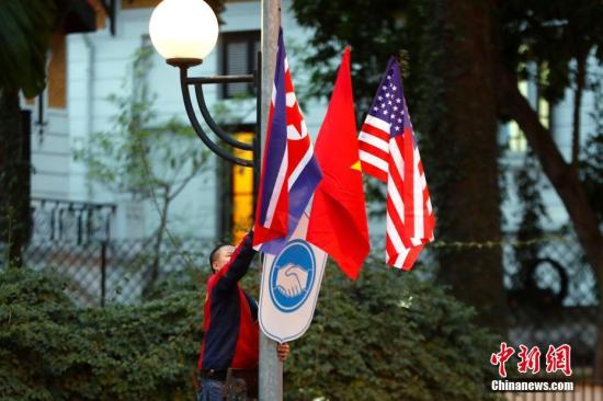 2月25日，越南首都河内，工作人员正在街头安装越南、美国、朝鲜三国国旗。朝鲜最高领导人金正恩与美国总统特朗普27日至28日将在越南首都河内举行第二次会晤。 中新社记者 富田 摄