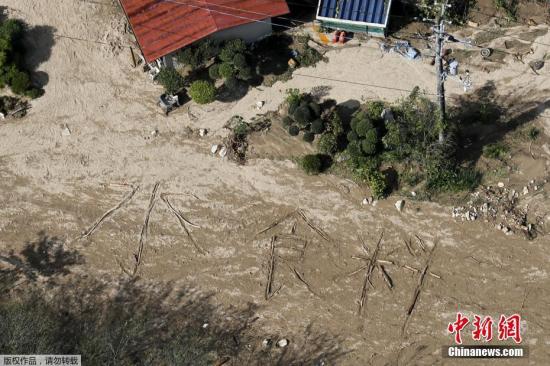 当地时间10月15日，台风“海贝思”登陆日本三天后，日本宫城县偏远地区丸盛市灾民在地上写出“水、食物”字样寻求援助。