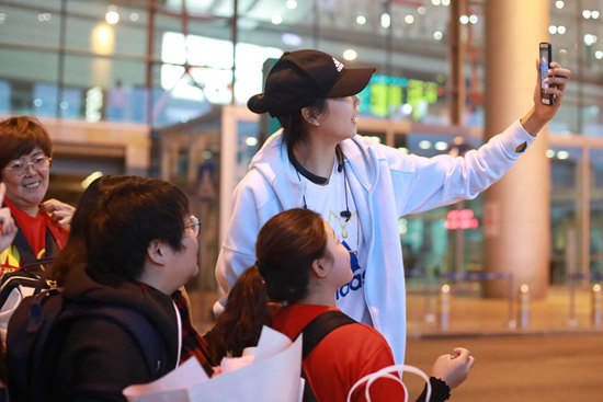 中国女排在机场与粉丝互动合影