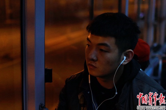 凌晨乘坐夜班车的年轻人沉浸在音乐里。中国青年报·中青在线记者 郑萍萍摄