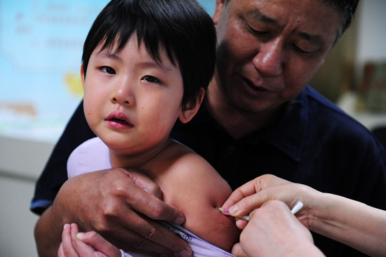 2010年9月11日,山西太原妇幼保健院防控室内,家长们带着孩子接种麻疹