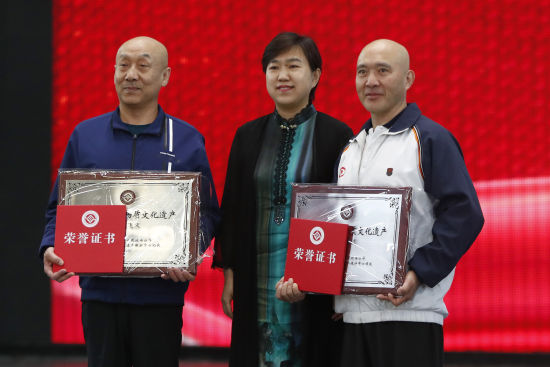 图为中国杂技团党委书记,董事长齐红(中)为井小毅(右),王斌(左)颁发