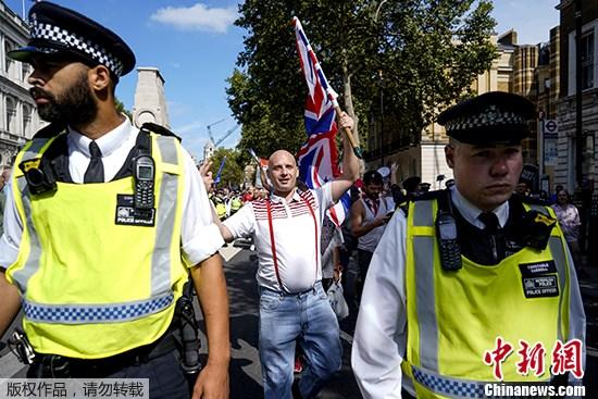 资料图：当地时间8月31日，近万英国民众聚集在英国政府所在地的伦敦唐宁街示威，抗议首相鲍里斯·约翰逊“暂停议会”。一部分脱欧支持者也走上街头，在警察的“护送下”前行。